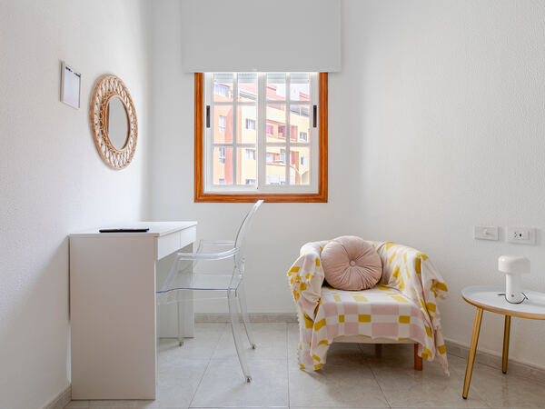 Desk and armchair in bedroom — De Villa Suites